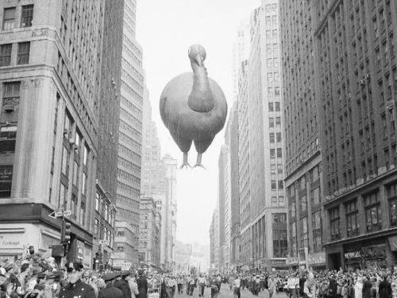 Macy's Day Parade features a large turkey balloon flying over a city street, creating a festive atmosphere.