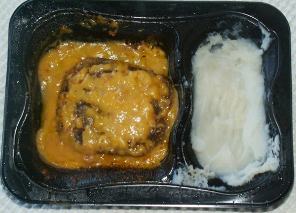 19 Meals Every College Student Knows Well: A black plastic container with mashed potatoes and gravy.