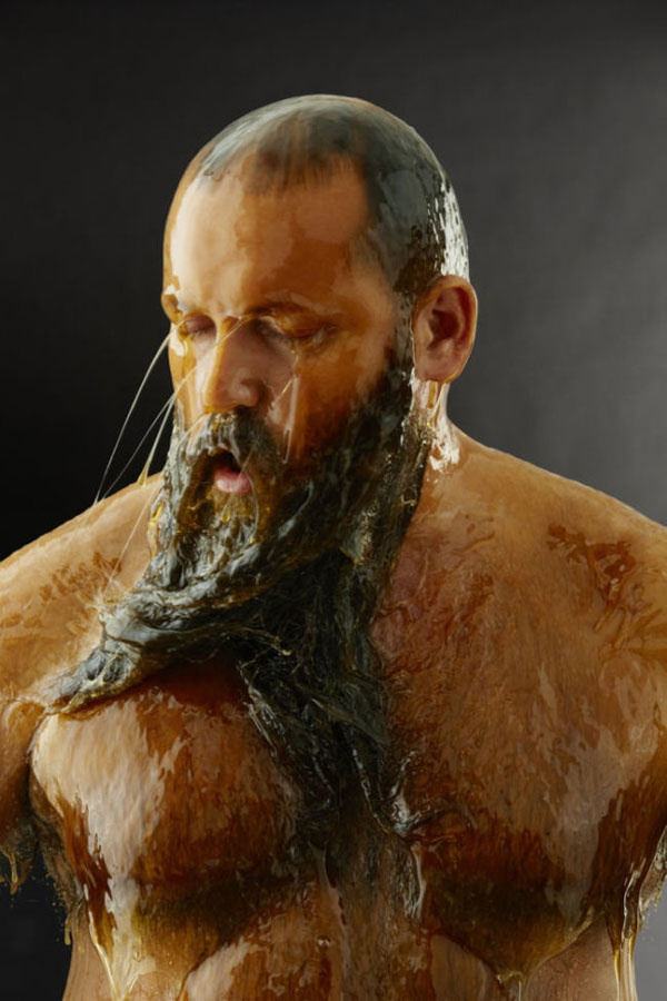 A man completely drenched in water with a beard covered in honey.
