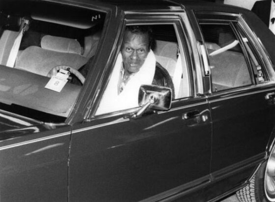 A man, embodying the true spirit of Legends of Rock N Roll, sits confidently in the driver's seat of a car.