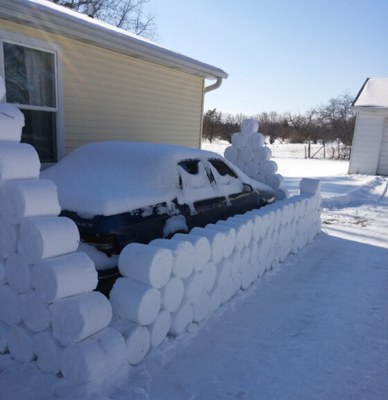 A car parked next to a snow wall.