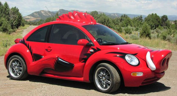 A WTF car - a red VW Beetle with a pig's head on it.