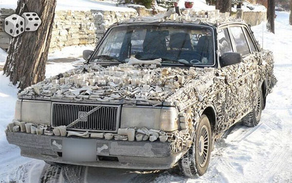 A WTF car covered in bones on the side of the road.