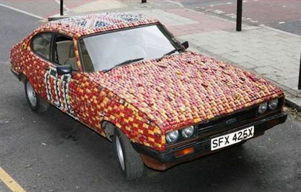 A WTF car on the side of the road covered in apples.