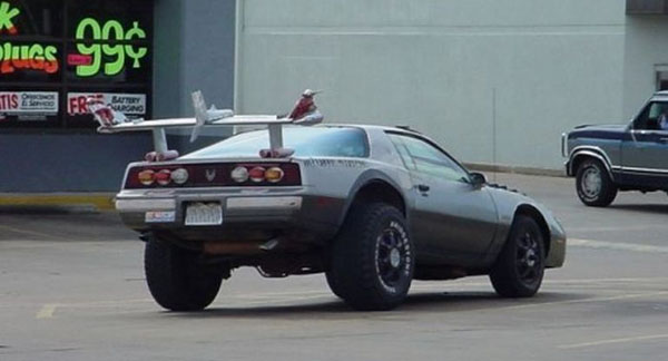 A WTF car, a delorean, parked in front of a gas station.
