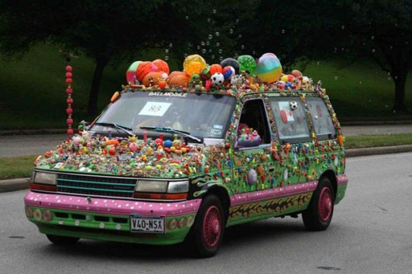 A WTF van covered in candy is driving down the street.