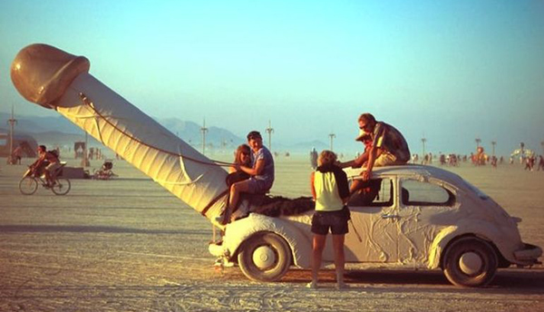 A group of people sitting on top of an old car that is just plain wrong.