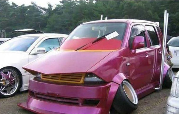 A WTF-worthy pink car parked in a parking lot.