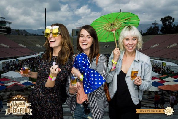 A group of women holding drinks and umbrellas during their Weekend Confessions.