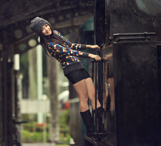 A woman is leaning on the railing of a train, capturing moments for Let's take a trip down photography lane [42 PICS].