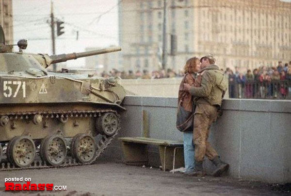 A romantic couple kissing on a bench next to a tank. [30 PICS]