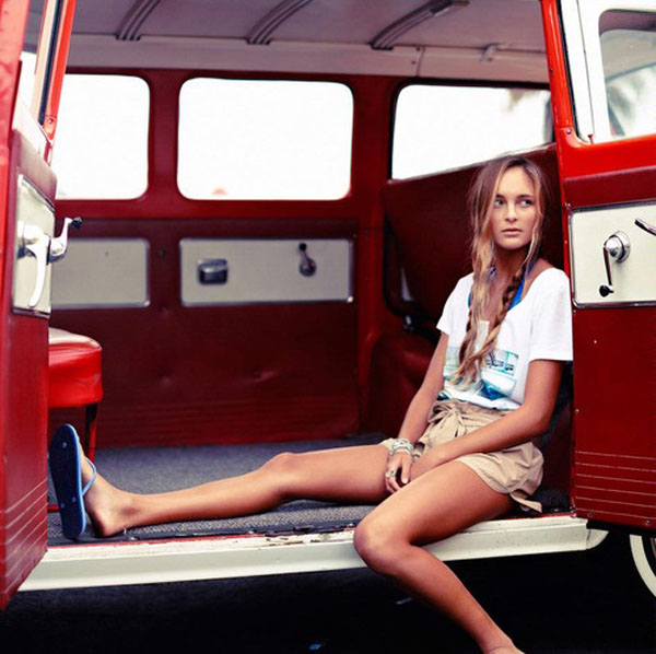 A babe relaxing in the back of a red van.