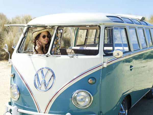 A woman is cruising in a desert with her VW bus, embracing the Babes and Dubs lifestyle.