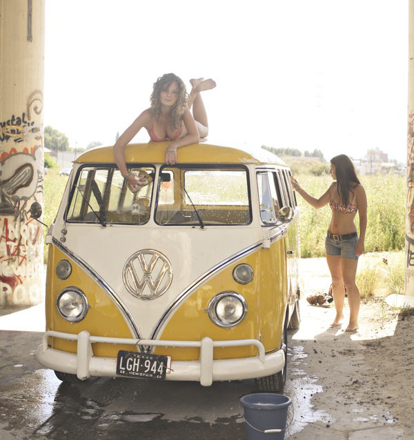 A babe is perched atop a yellow VW dub.