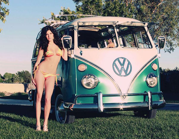 A babe posing beside a dubs-inspired VW bus.