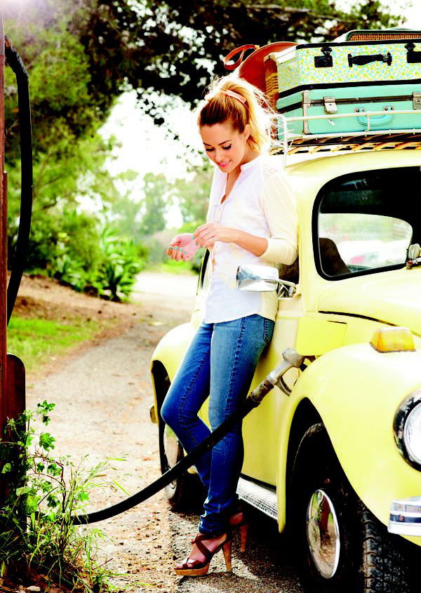 A babe posing with a yellow VW Beetle.