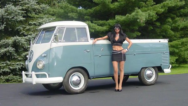 A babe posing by a VW bus in a bikini.