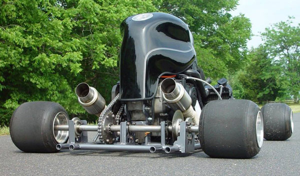 A sleek black go-kart parked on the side of the road.