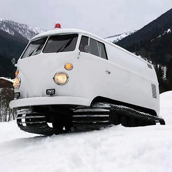A cool white VW bus cruising through the snow.