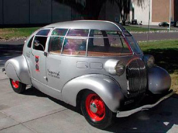 A silver car parked on the side of the road, yup, just cool.