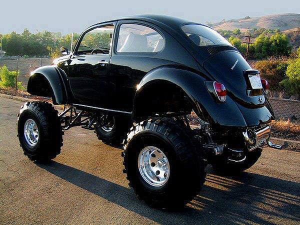 A black Volkswagen beetle is parked on the side of the road.