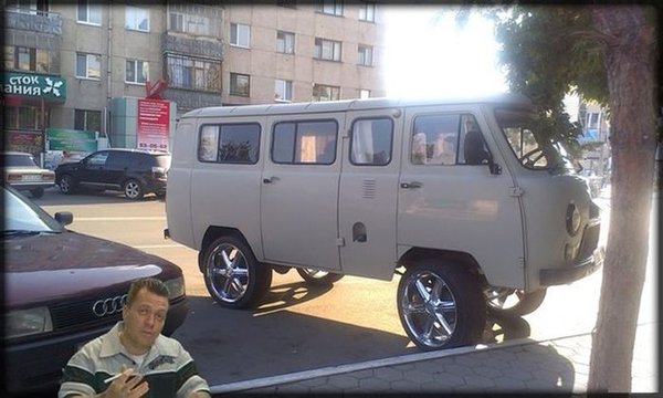 A man is standing next to a cool white van.