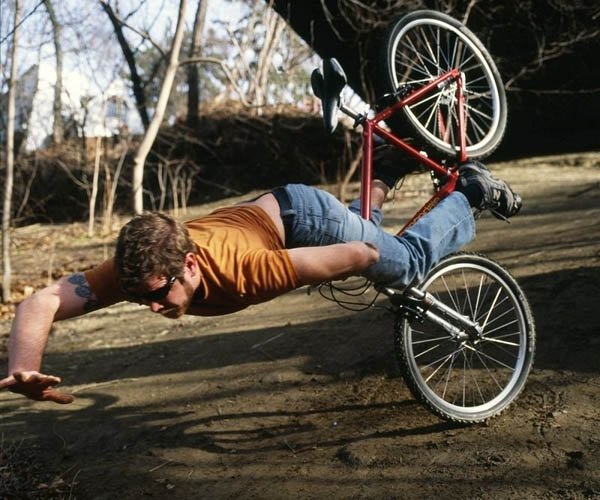 A man face plants while doing a trick on a bike.