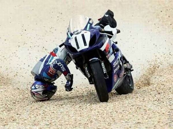 A person face plants while riding a motorcycle on a dirt track.