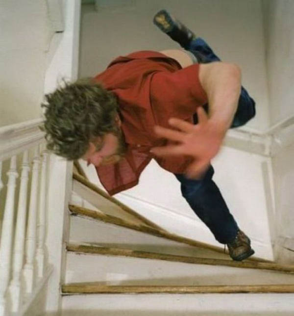 A man face plants while falling down a set of stairs.