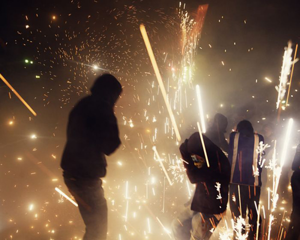 A group of people are holding sparklers, capturing Most Insane Fireworks Pictures (14 Pics), in the dark.