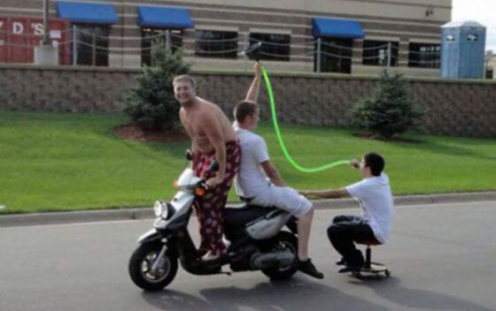 A group of people on a motorcycle, a little drunk, with a green hose.