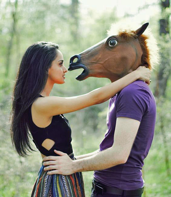 A woman wearing a horse mask, making a peculiar fashion statement.