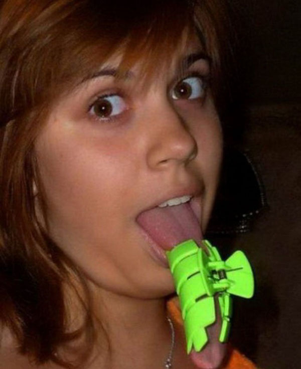 A girl with a green bow tie on her tongue, portraying an intriguing element of charm.