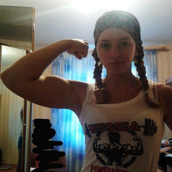 A woman is posing with her impressive biceps, showcasing strength and femininity.
