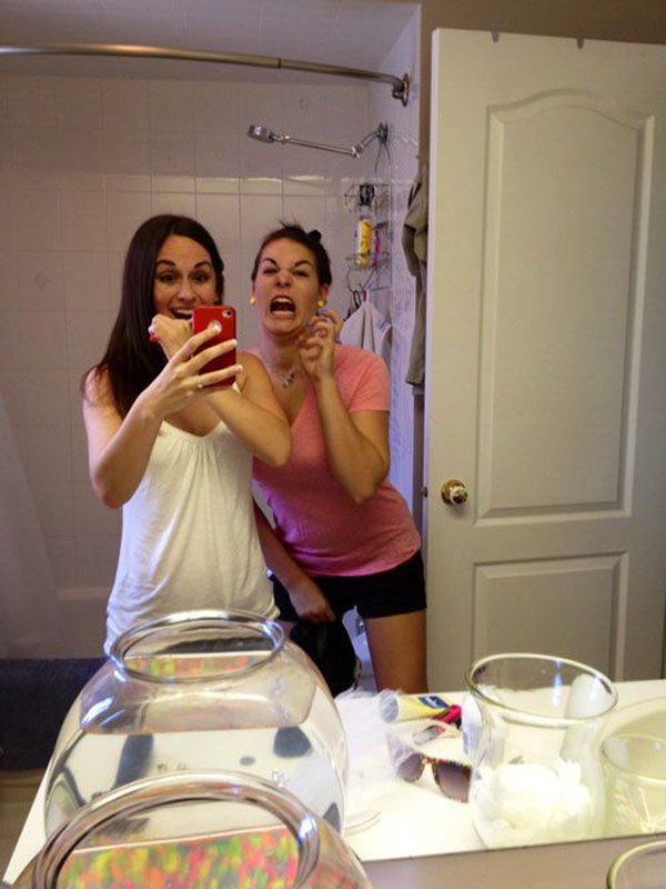 Two women taking a selfie in a bathroom, showcasing their friendship and the fun they share, capturing lighthearted moments.