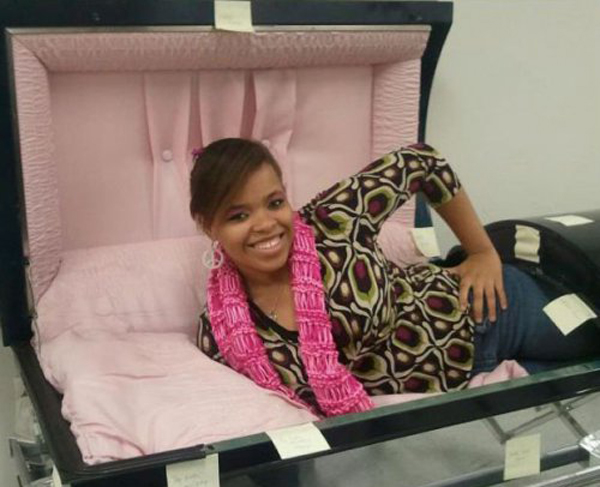 A woman laying in a pink casket for I Would Date You But... (part 2) event.