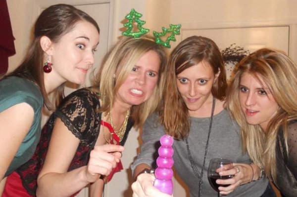 A group of women are posing for a picture with a purple toy in 