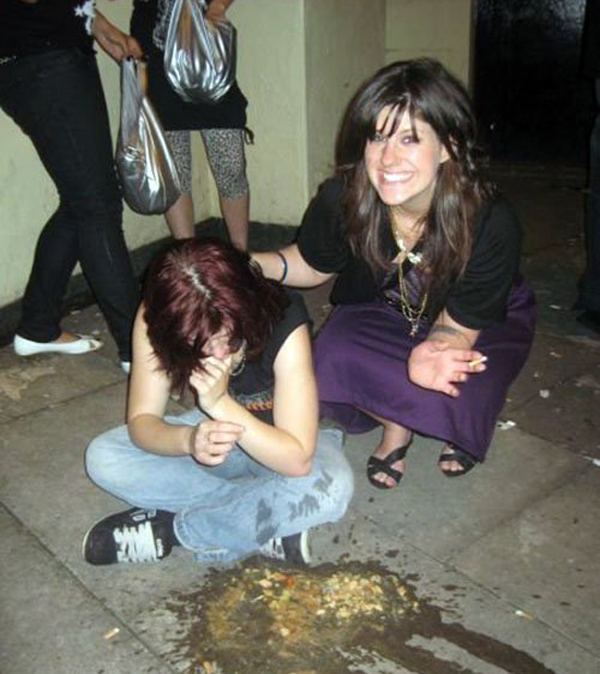 A woman kneeling on the ground next to a woman and saying 