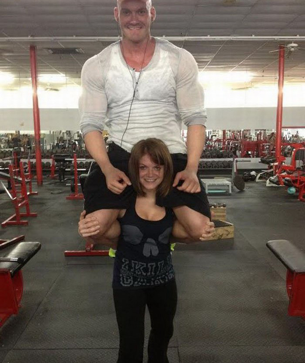 A man posing with a woman in a gym, showcasing their chemistry as potential dating partners in an 