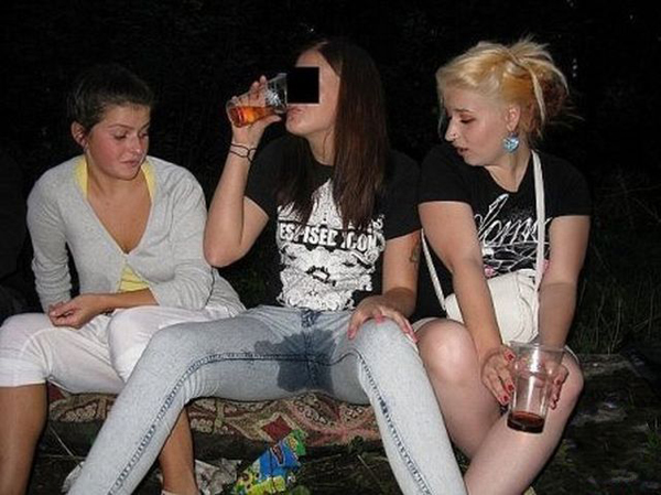 Three girls sitting on a bench drinking beer, enjoying their time together.