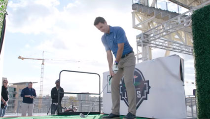 A man is hitting a golf ball on a putting green at Petco Park in San Diego, and it's awesome.