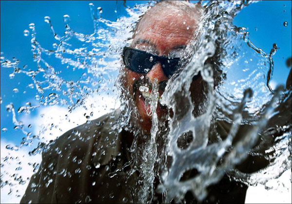 A man in sunglasses is splashed with water in this gallery showcasing the beauty of the world.