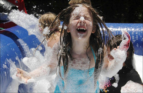 A girl is enjoying foam play at a water park.