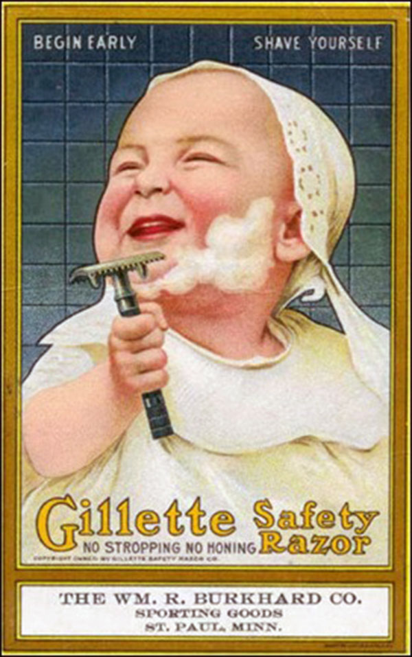 A baby is holding a razor and smiling.
