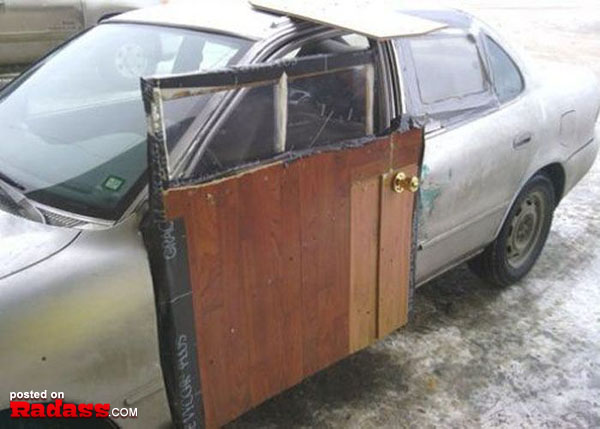A rustic car with a wooden door that is open.