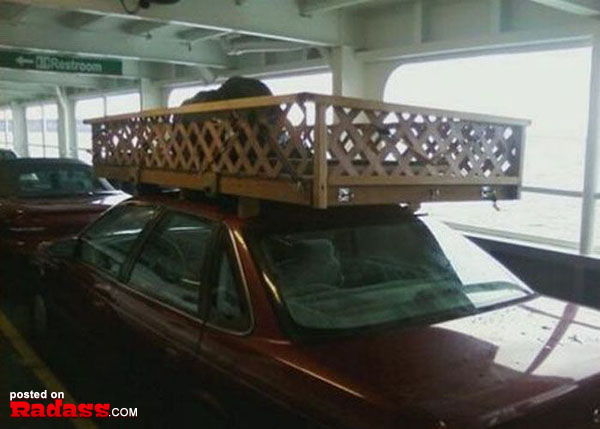 A car with a roof rack on top of it on a ferry, equipped for adventure and travel.