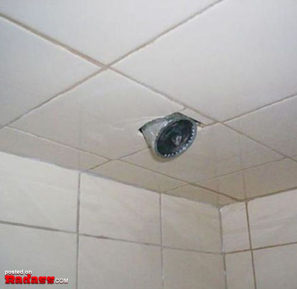 A shower head is mounted on a tiled ceiling.