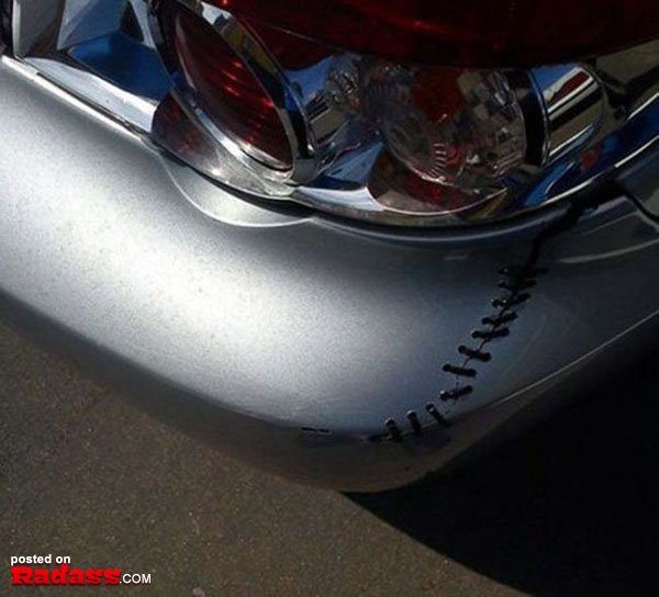 The rear bumper of a silver car with writing on it advertising 