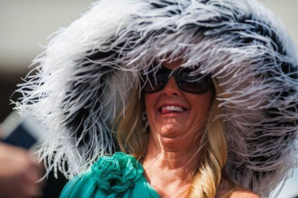 A woman wearing a large hat and sunglasses, embodying the essence of Kentucky charm.
