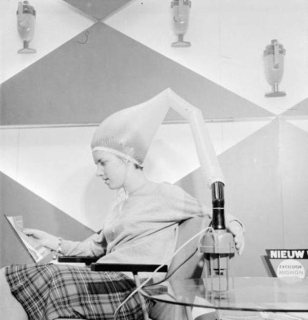 A woman with a laptop on her head, showcasing one of the ridiculously strange but cool inventions from the early 1900's.